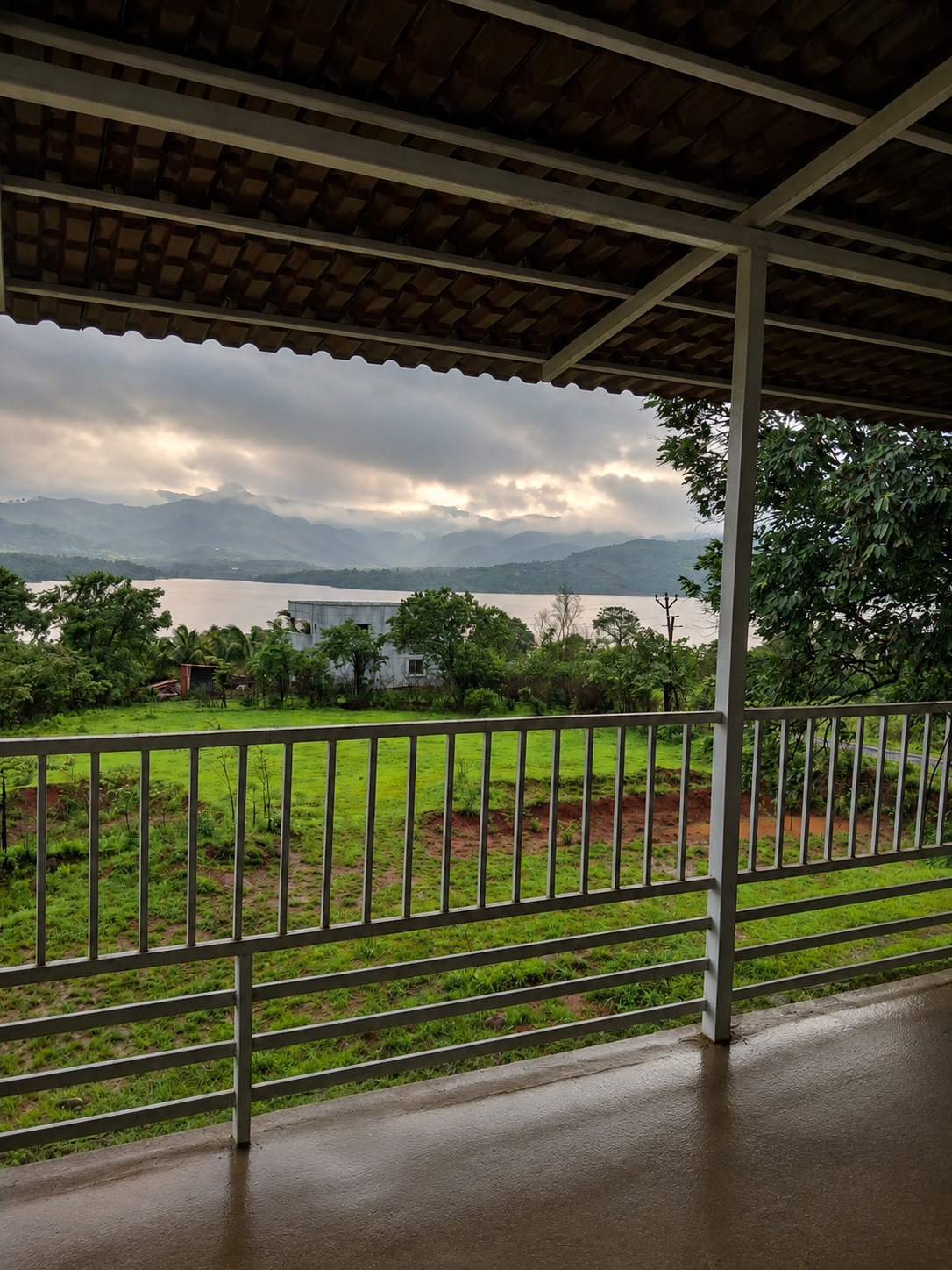 Covered balcony overlooking the green hills and lake at Aura Resort