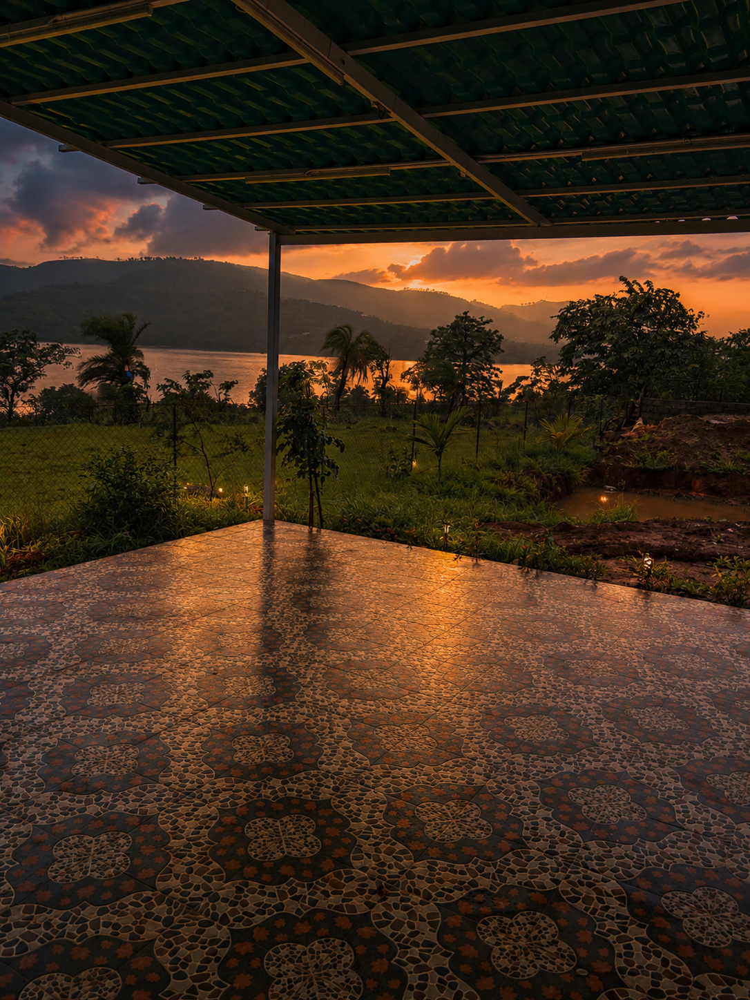 Lake-view patio at Aura Resort with sunset reflections and hills